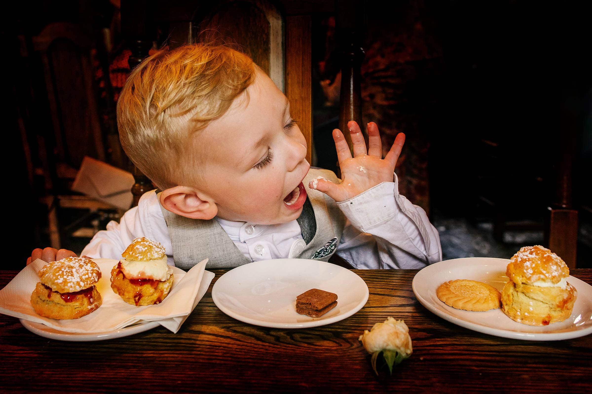 Child at a wedding eating scones photograph